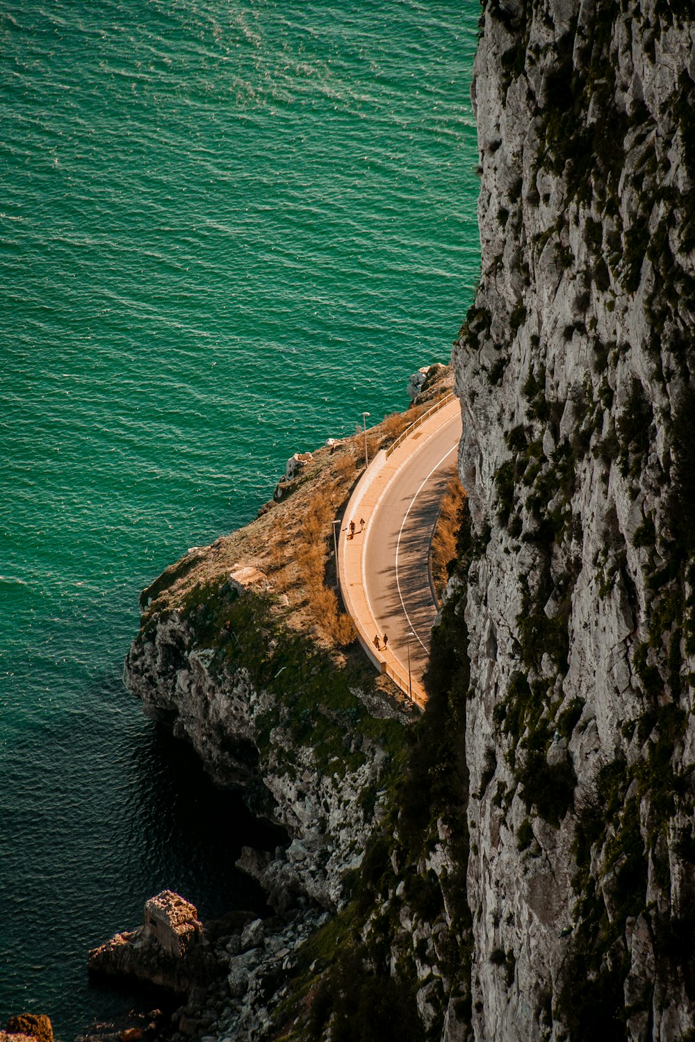 a car driving down a road next to the ocean