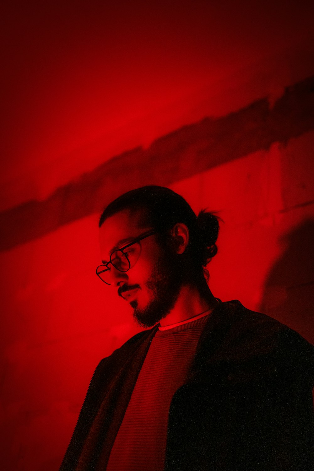 a man standing in front of a red light