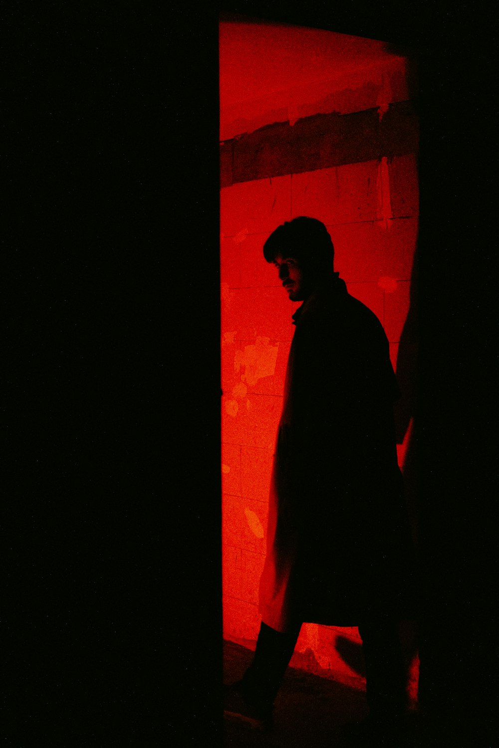a man standing in a doorway in a dark room