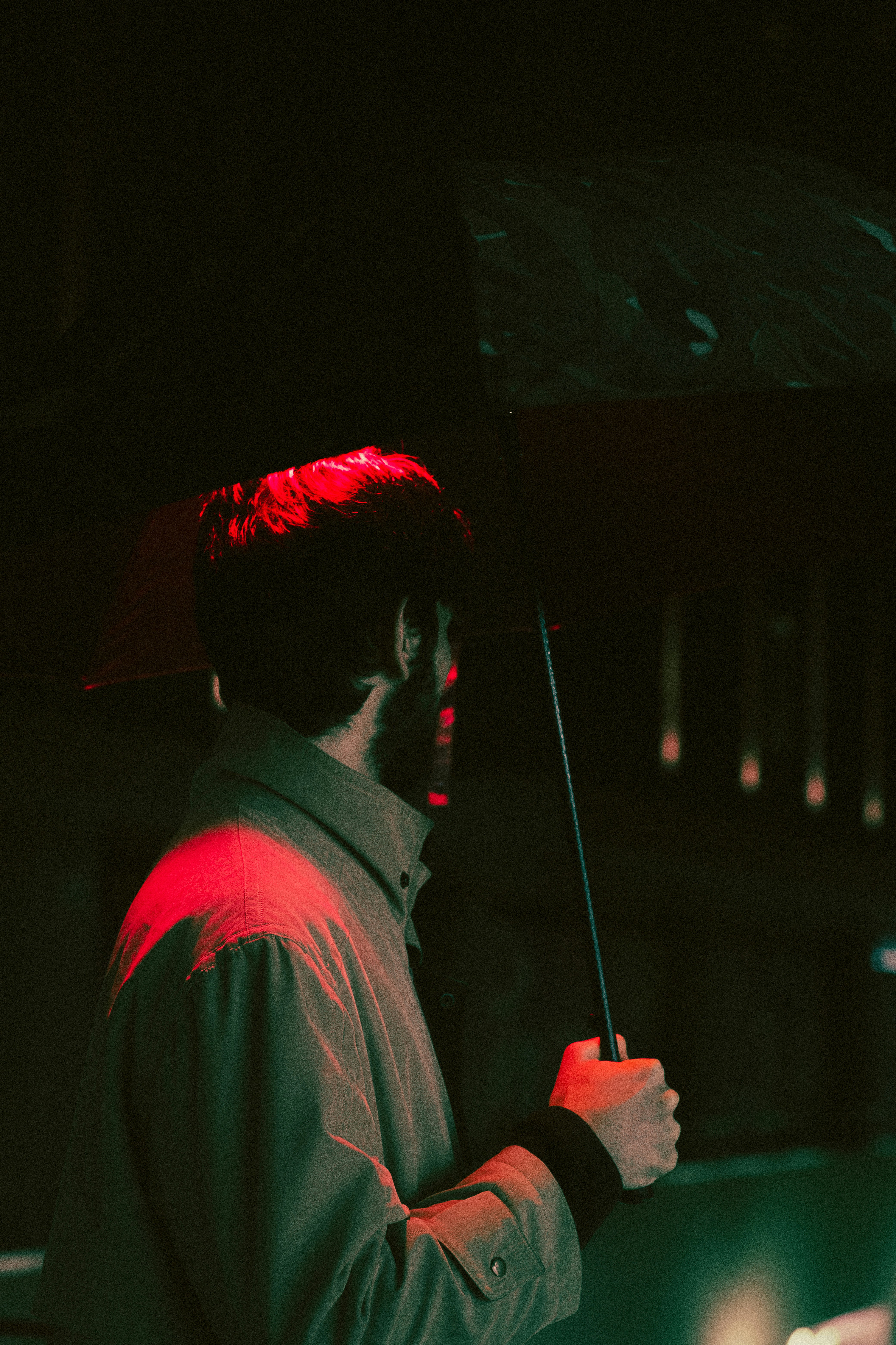 a man holding an umbrella in the dark