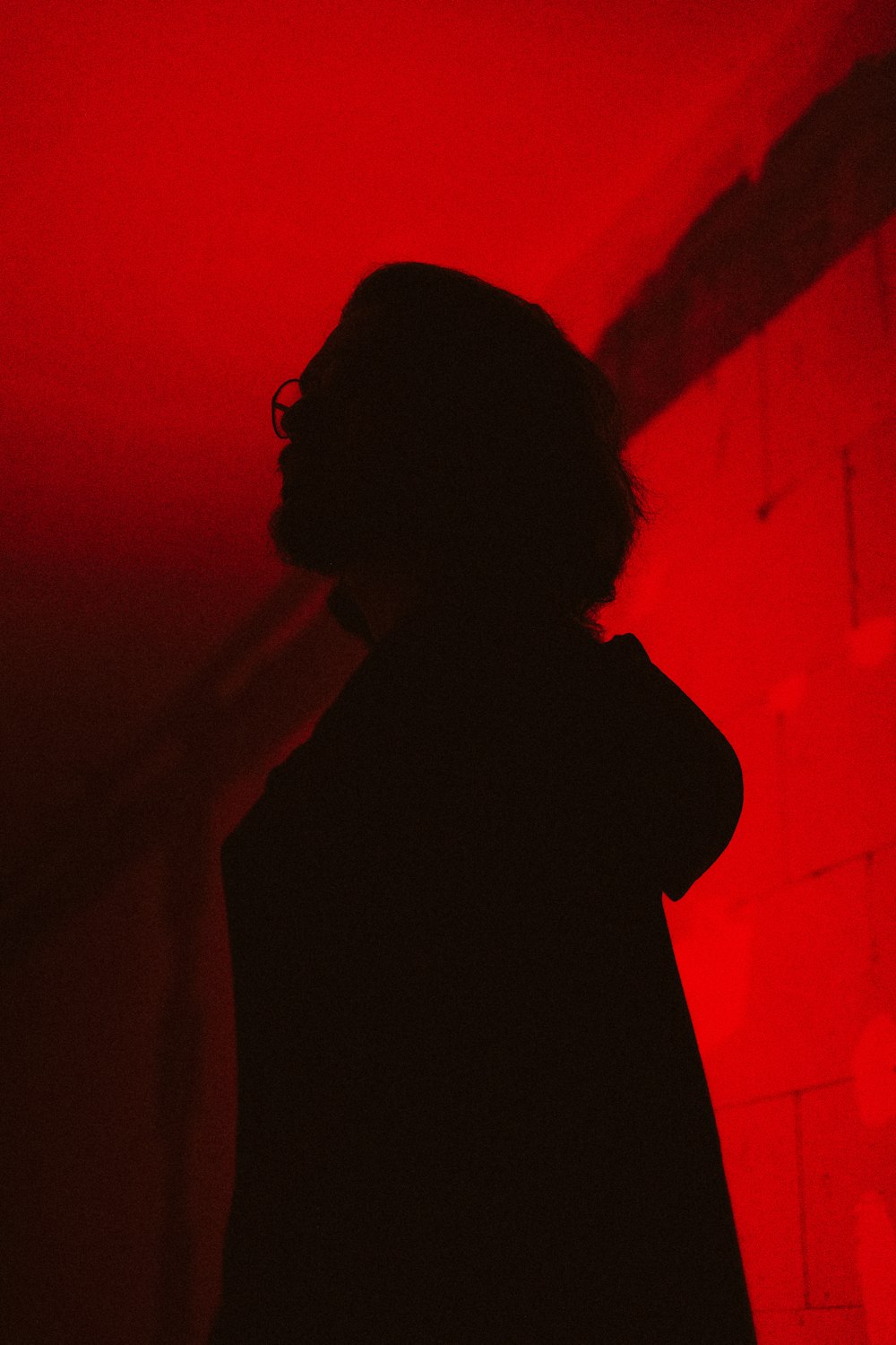 a person standing in a dark room with a red light