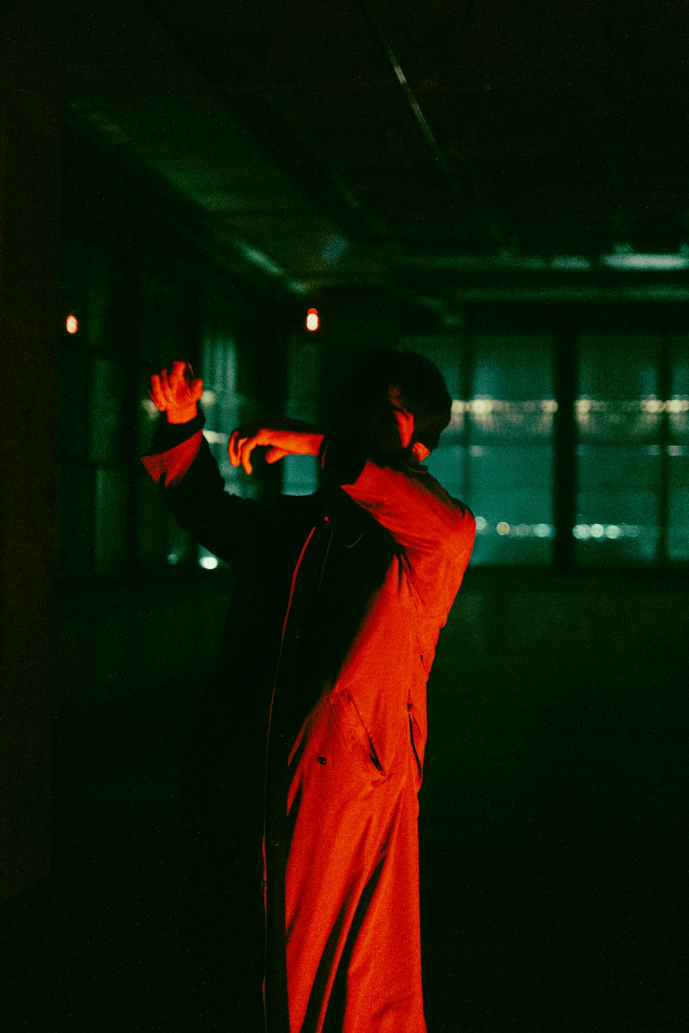 a man standing in a dark room with his arms outstretched