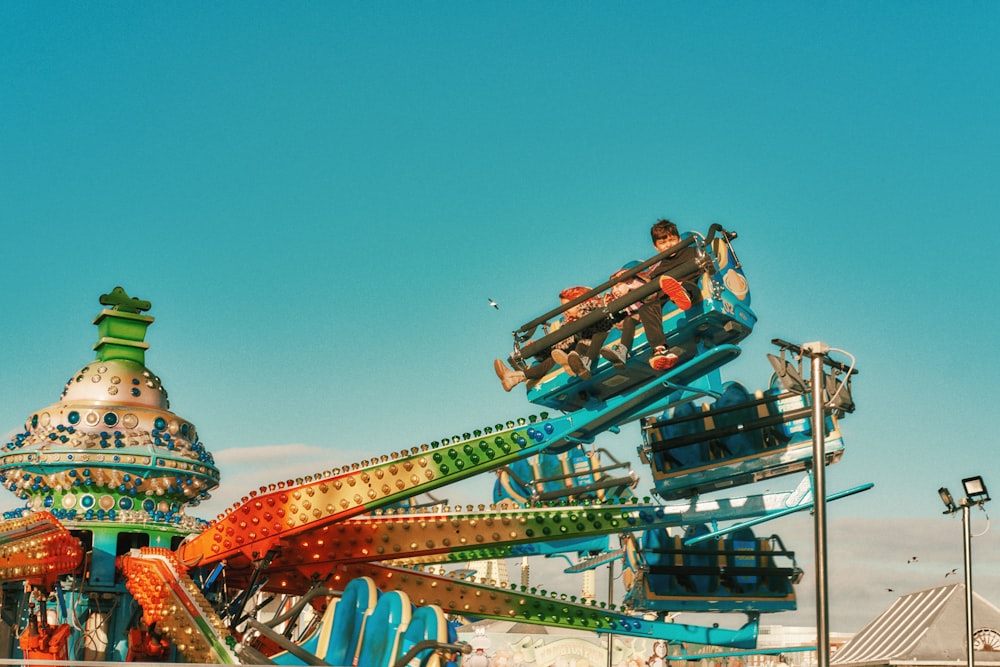 a roller coaster at a carnival with a sky background