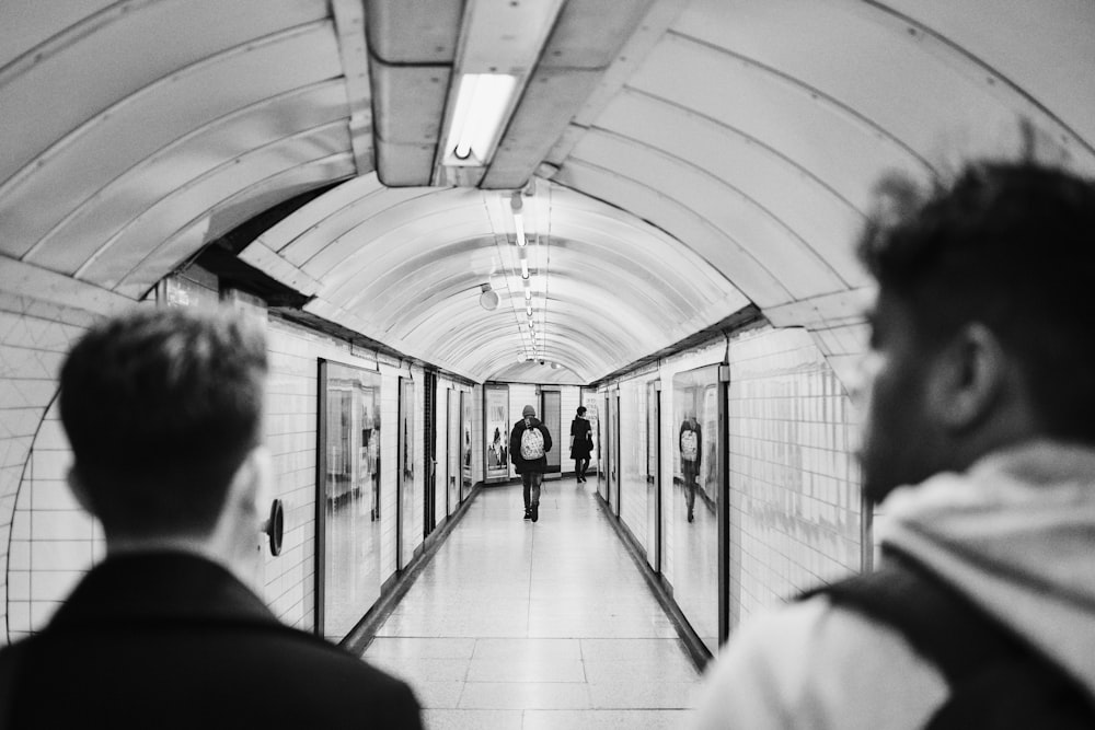 a couple of men walking down a long hallway