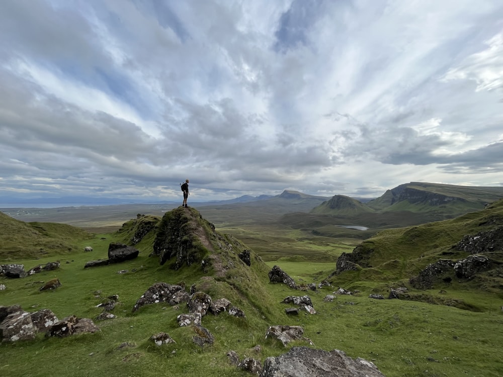 a person standing on top of a grass covered hill