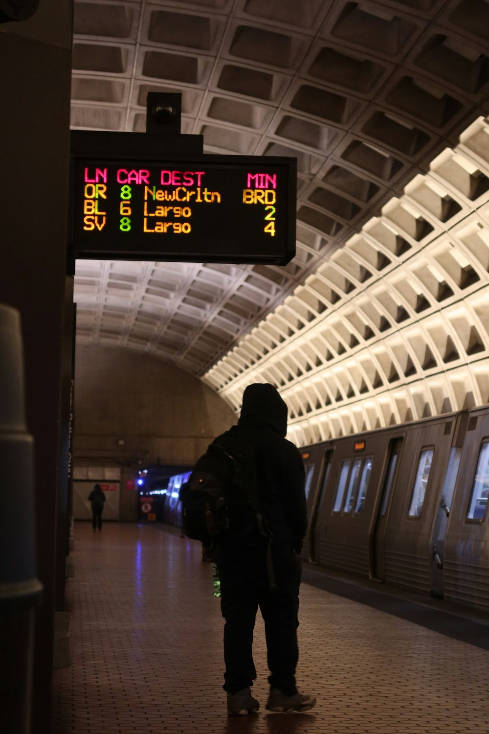 a person standing in a subway station waiting for a train