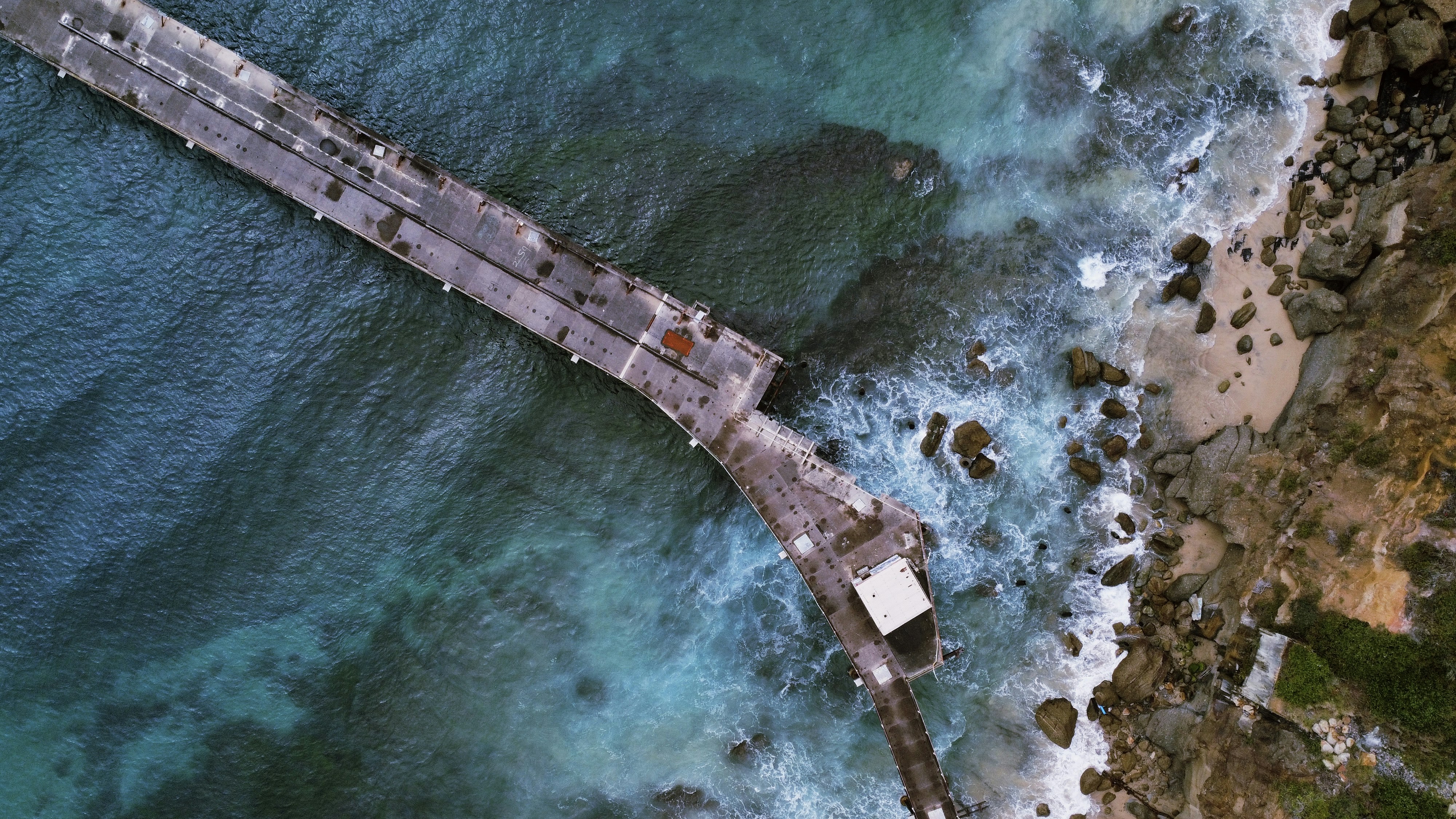 an aerial view of a pier in the ocean