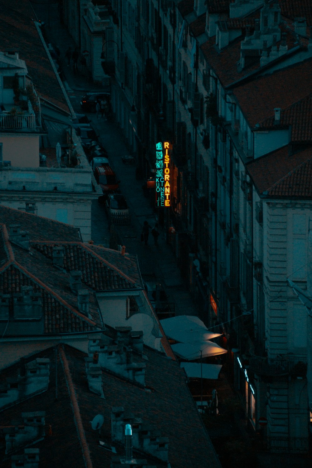 a city street at night with a neon sign on the building