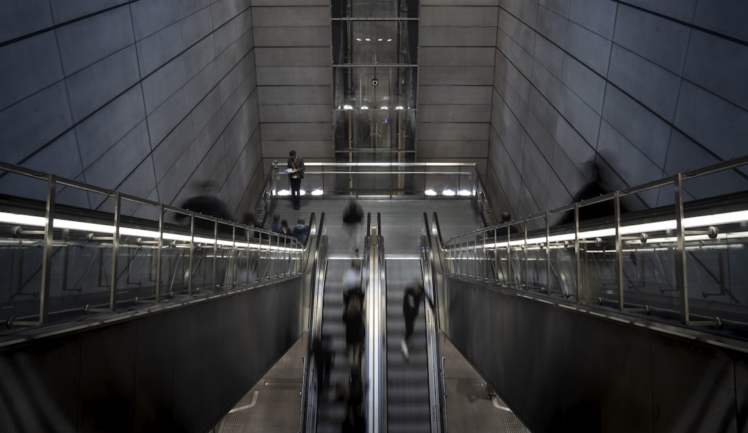 a group of people riding down an escalator,