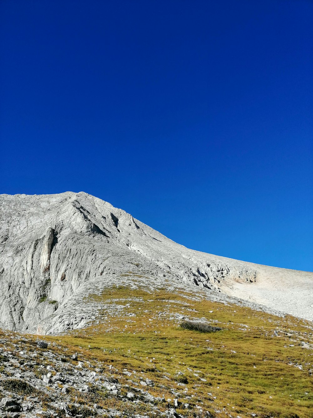 una montagna con un campo erboso sotto di essa