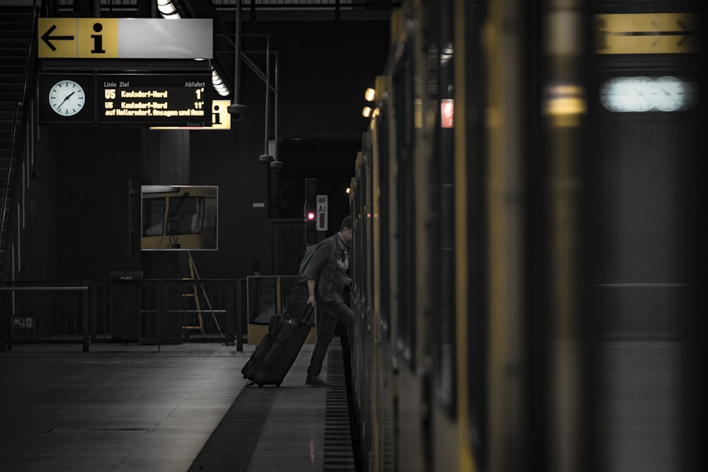 a man with a suitcase is waiting for the train