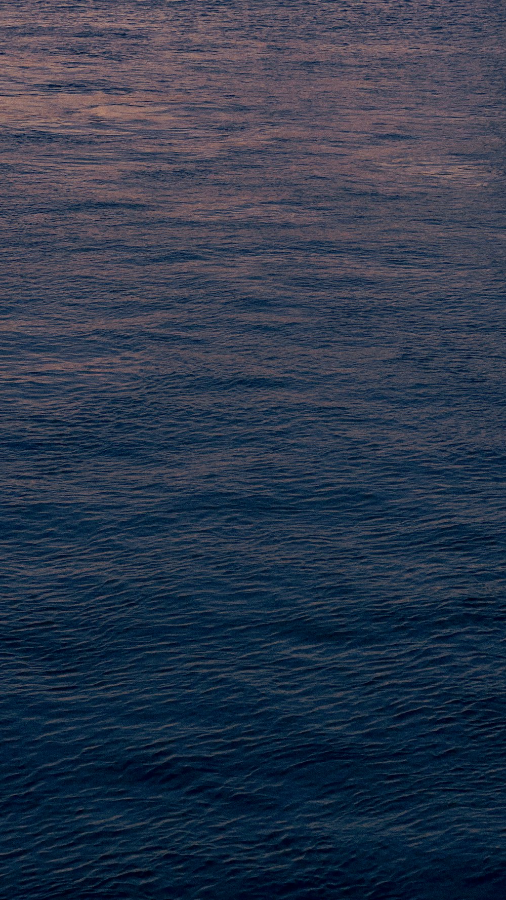 a large body of water with a boat in the distance