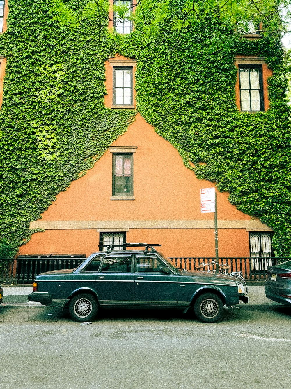 a car parked in front of a building covered in vines