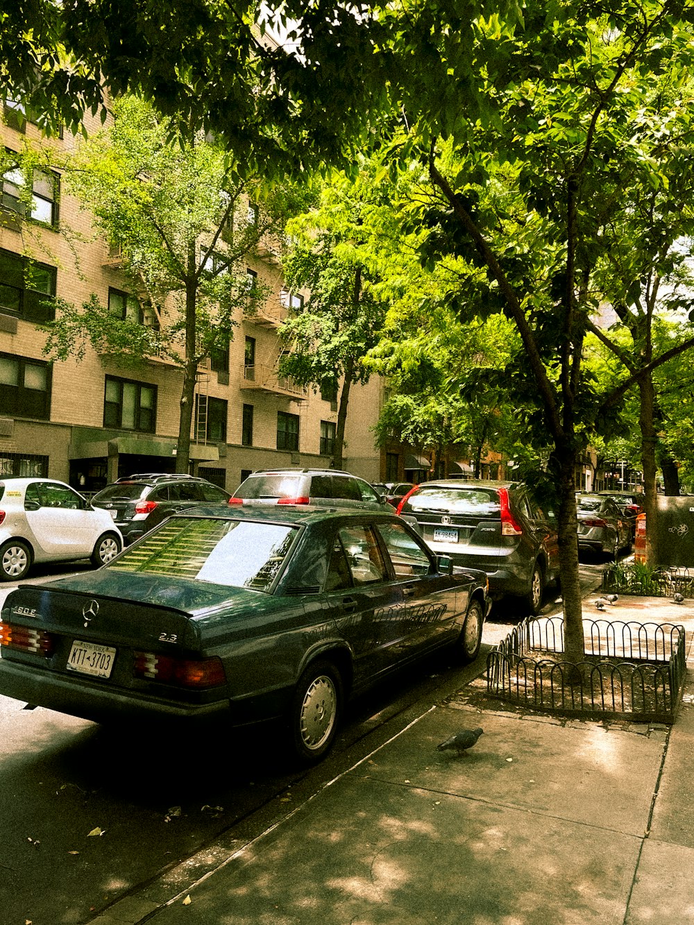 a green car parked on the side of a street