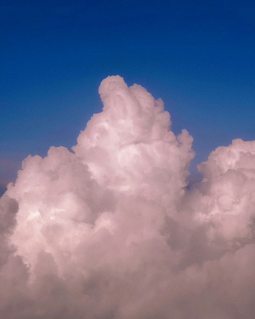 a plane flying through a cloud filled sky