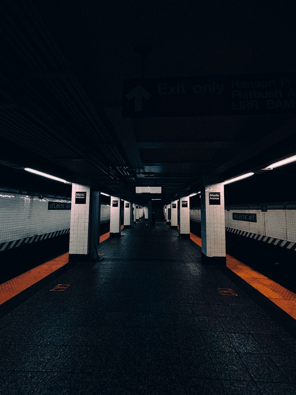 a subway station at night with no people on the platform
