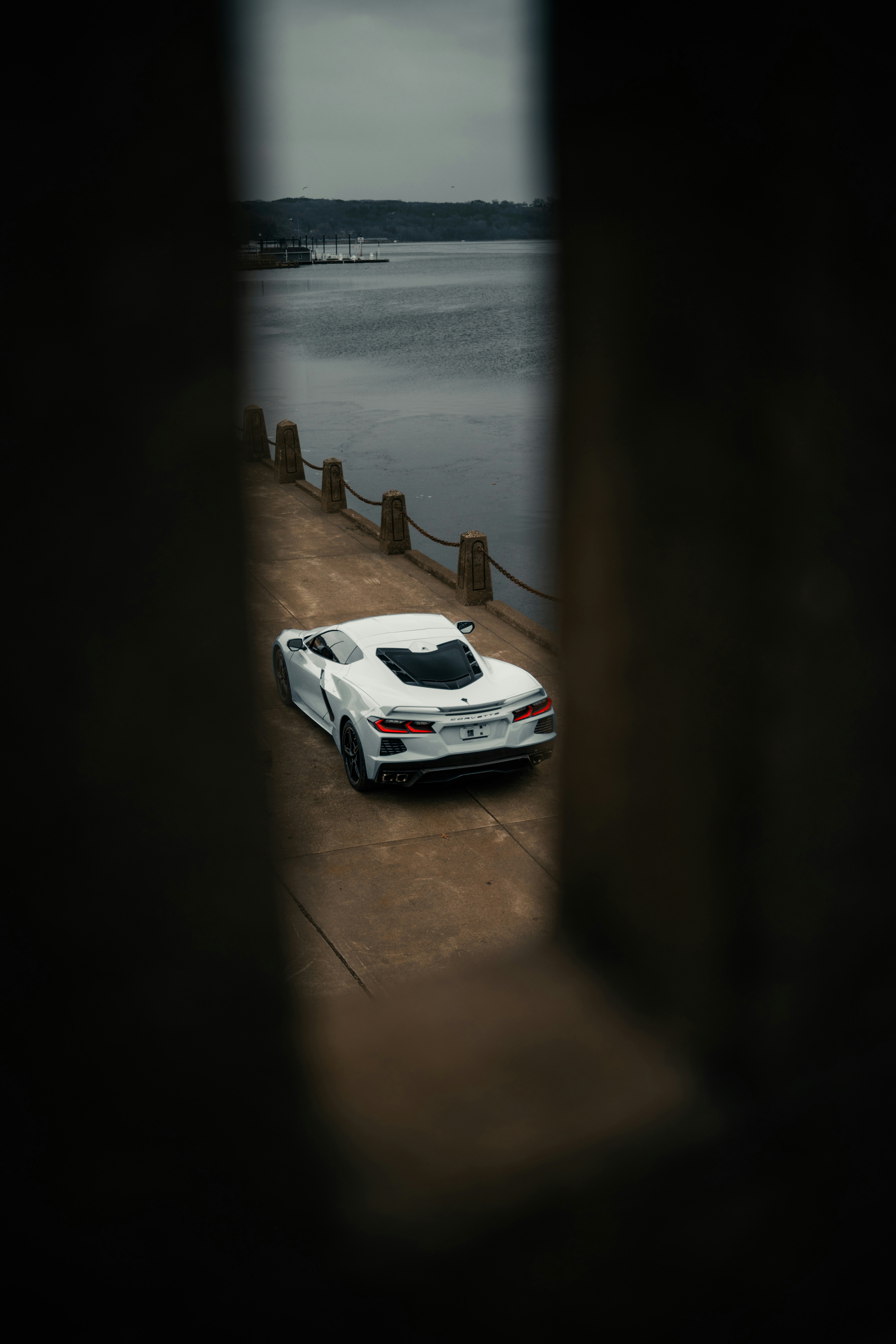 une voiture de sport blanche garée à côté d’un plan d’eau