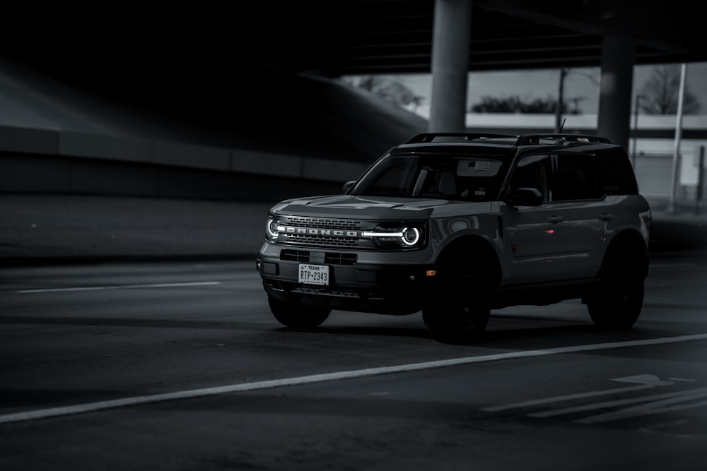 a black and white photo of a car in a parking garage