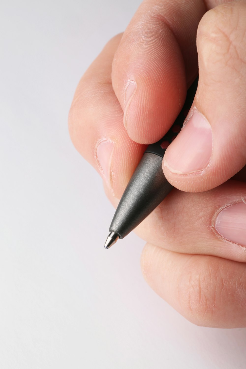 uma pessoa segurando uma caneta na mão esquerda