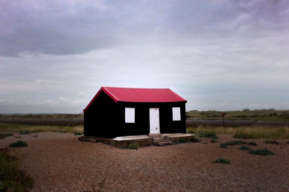 a small black house with a red roof