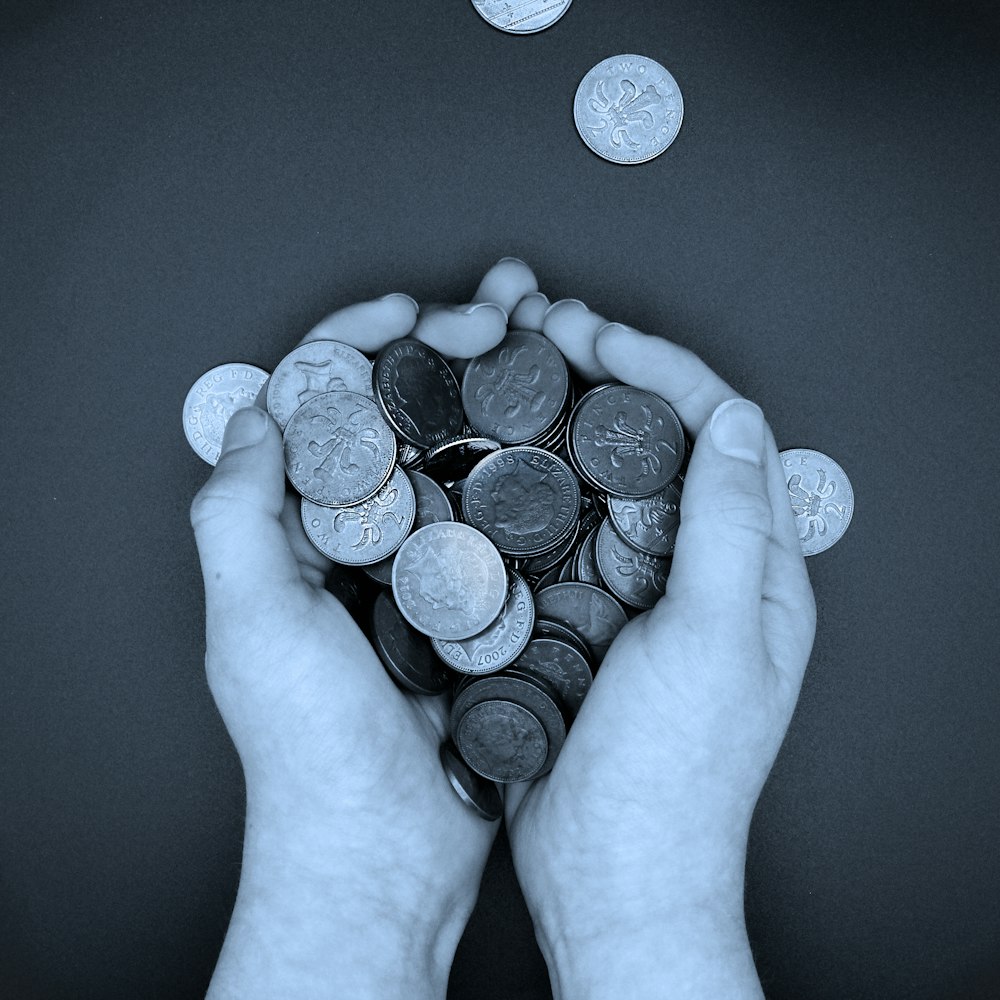 a person holding a bunch of coins in their hands