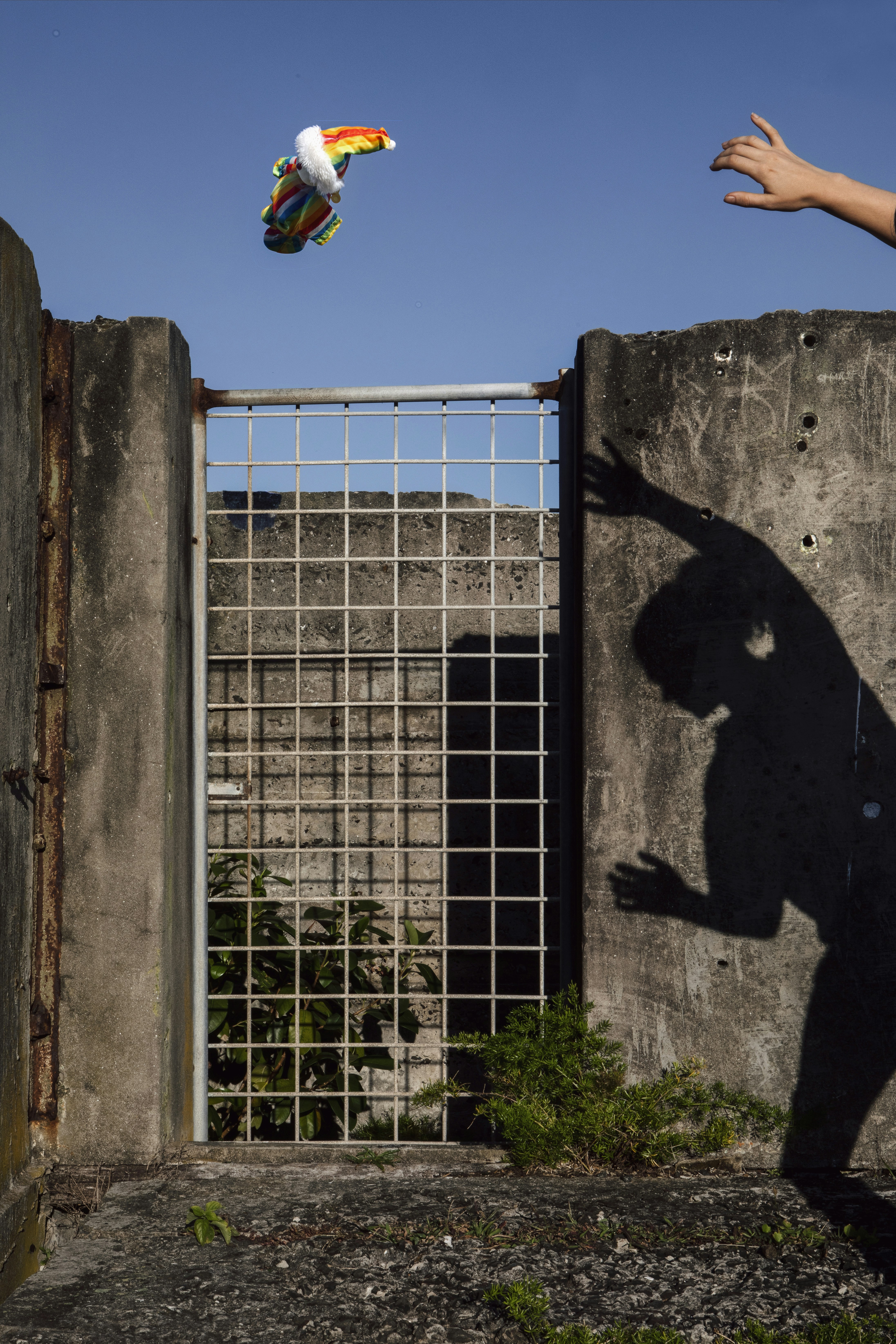 a man flying a kite over a cement wall