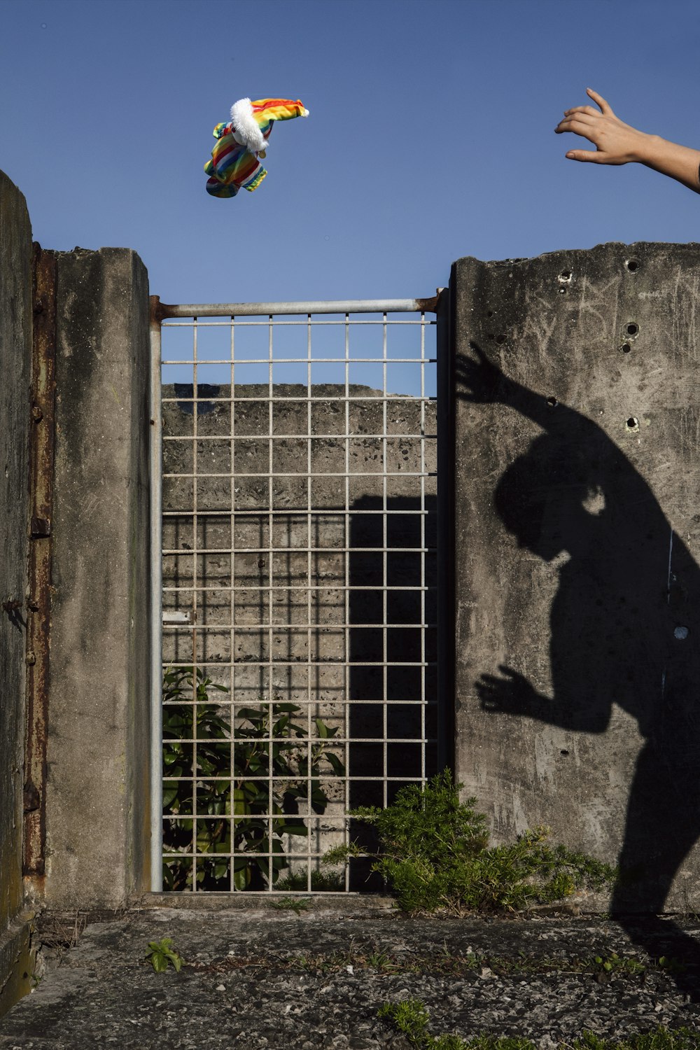 a man flying a kite over a cement wall