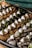 An appetizing presentation of sushi rolls adorned with creamy dollops and sprinkled with sesame seeds and chopped green onions. The sushi is arranged neatly on a black platter, with a mixture of crispy and soft textures, drizzled with a dark sauce.
