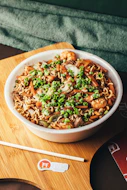 a bowl of noodles and vegetables on a cutting board