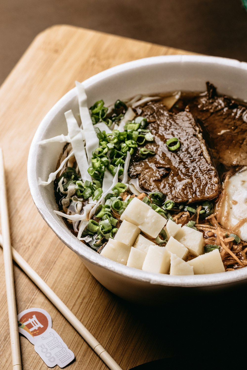 a bowl of food with chopsticks on the side