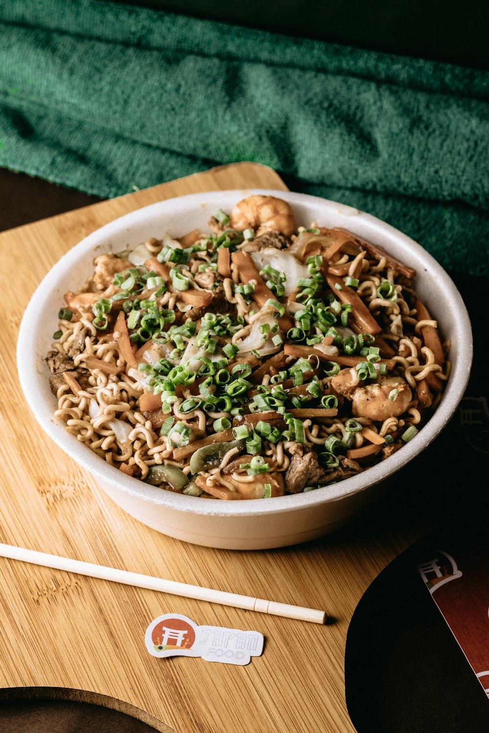 a bowl of noodles with mushrooms and green onions