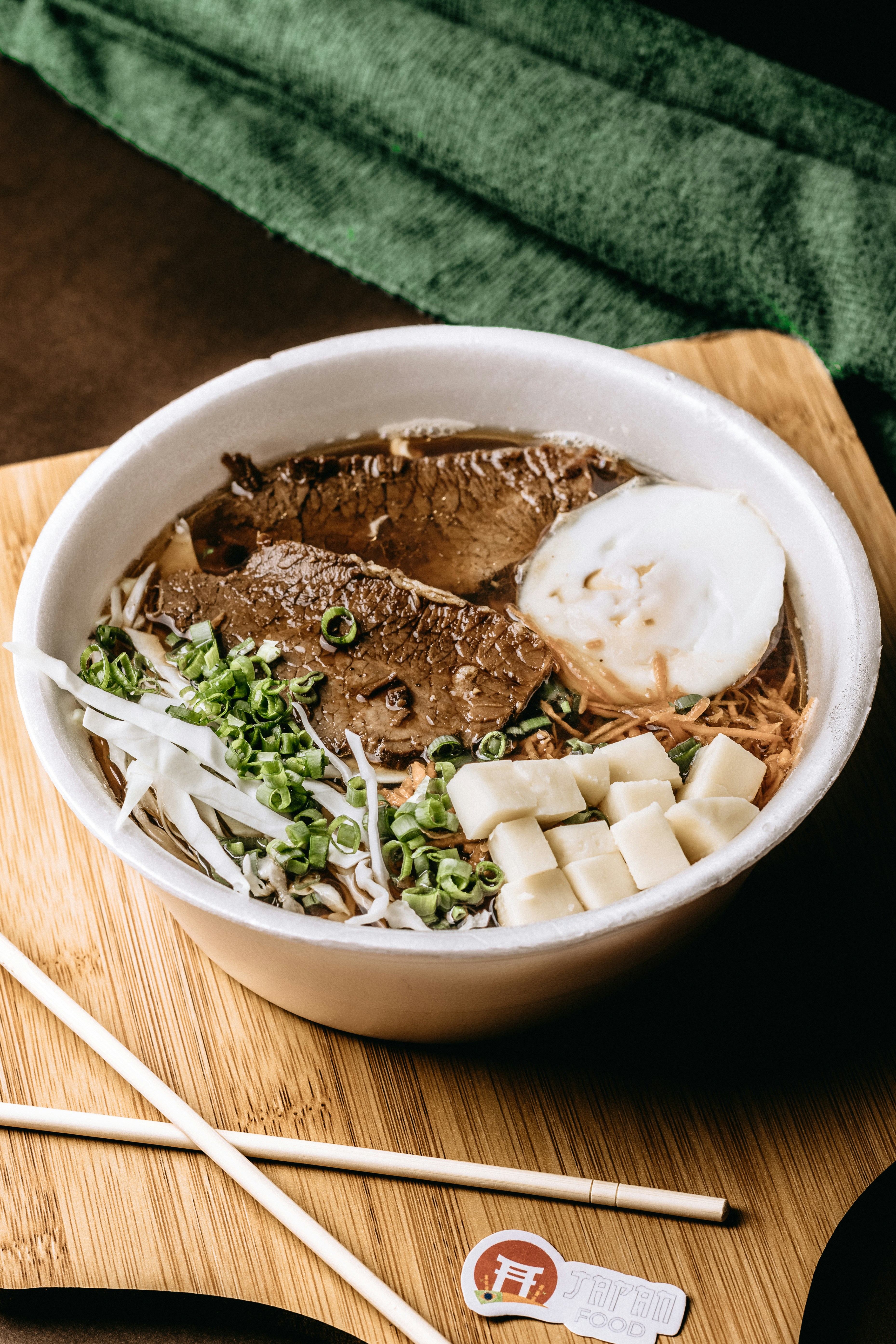 a bowl of food on a cutting board with chopsticks