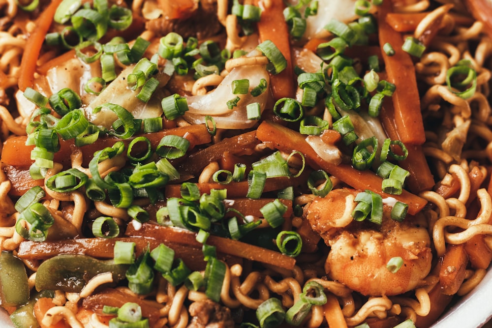 a close up of a plate of food with noodles and vegetables