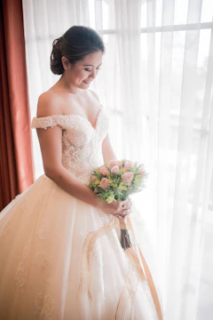 A radiant bride smiling under soft natural light, her bouquet in vivid color.