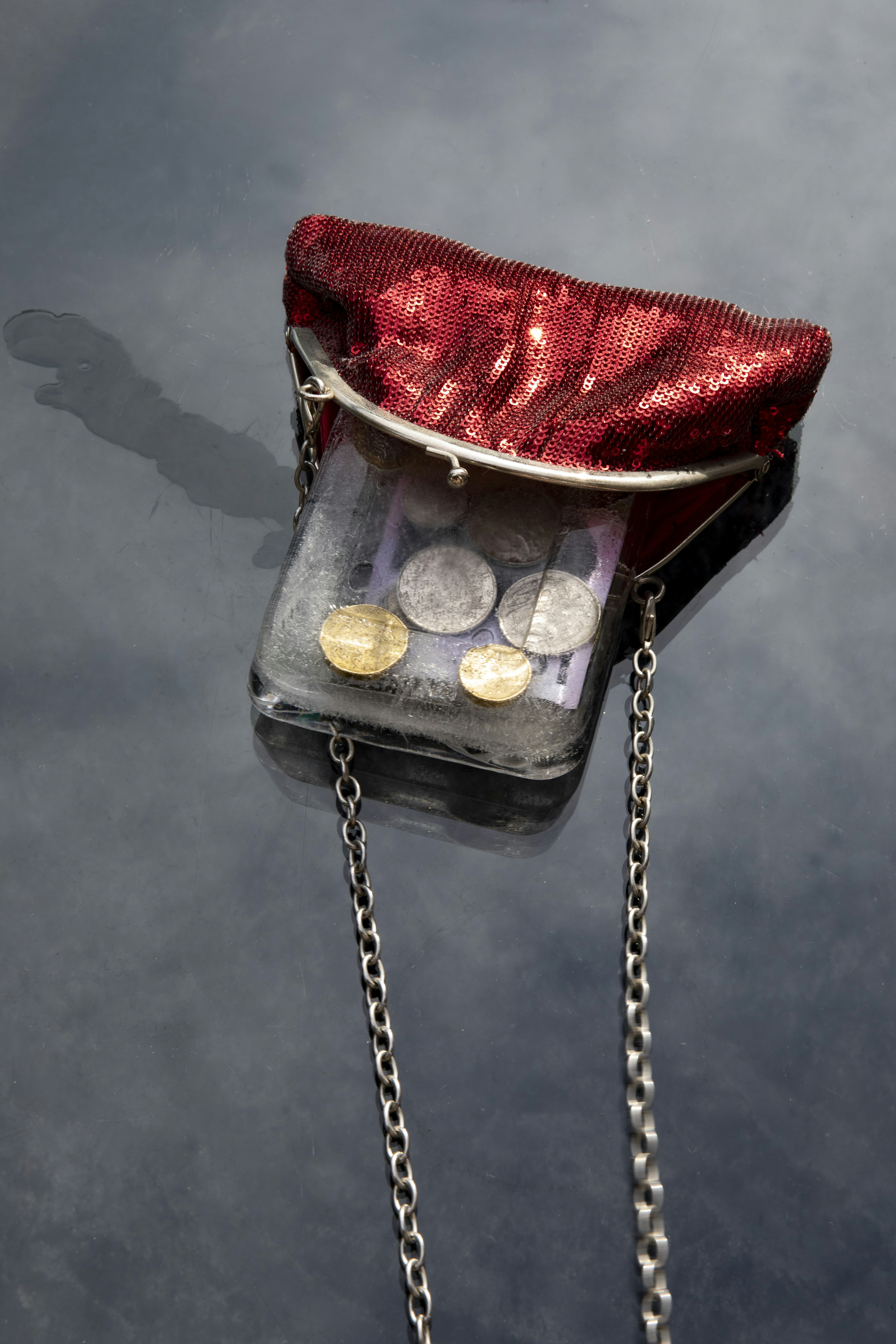 a purse with coins in it sitting on the water