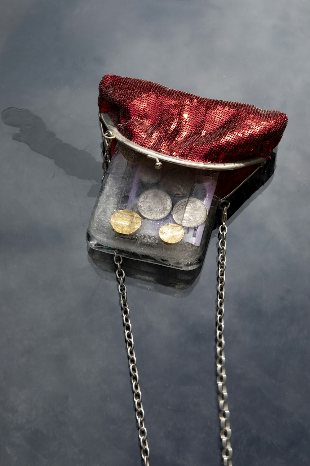 a purse with coins in it sitting on the water