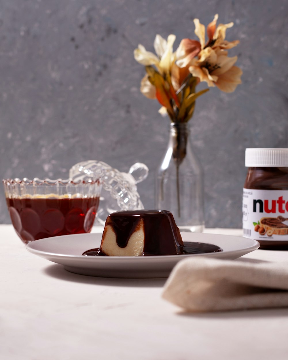 a plate with a piece of cake on it next to a jar of nutella