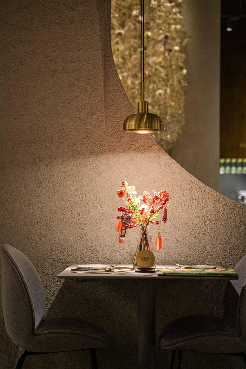 a table with two chairs and a vase with flowers on it