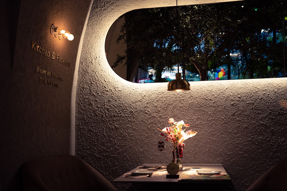 a table with a vase of flowers on it in front of a window