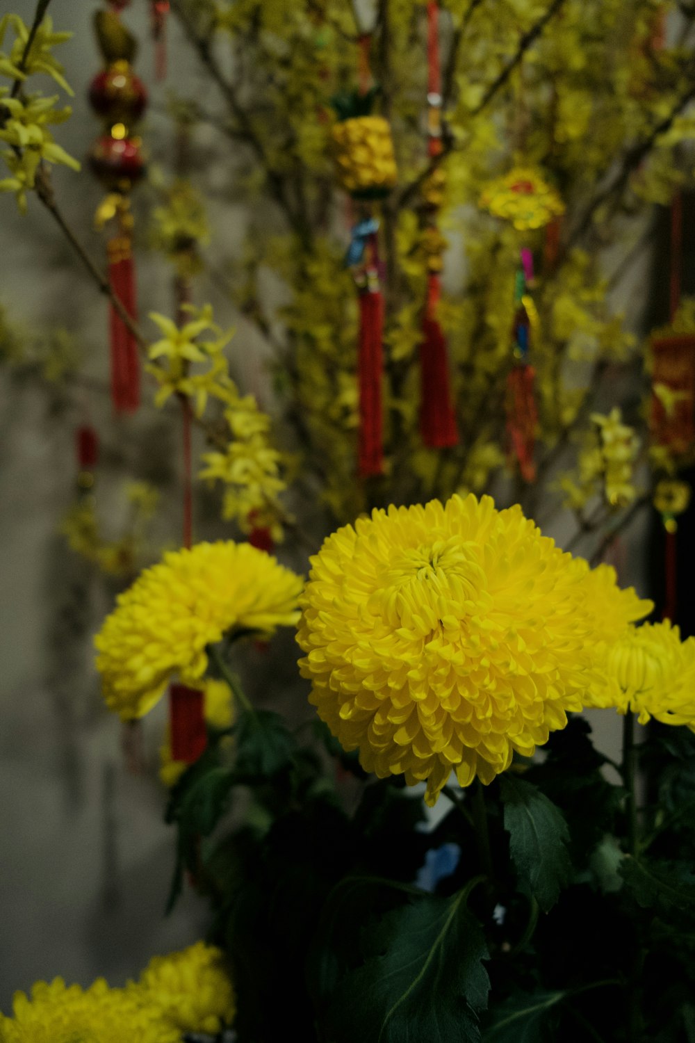 a vase filled with yellow flowers next to a tree