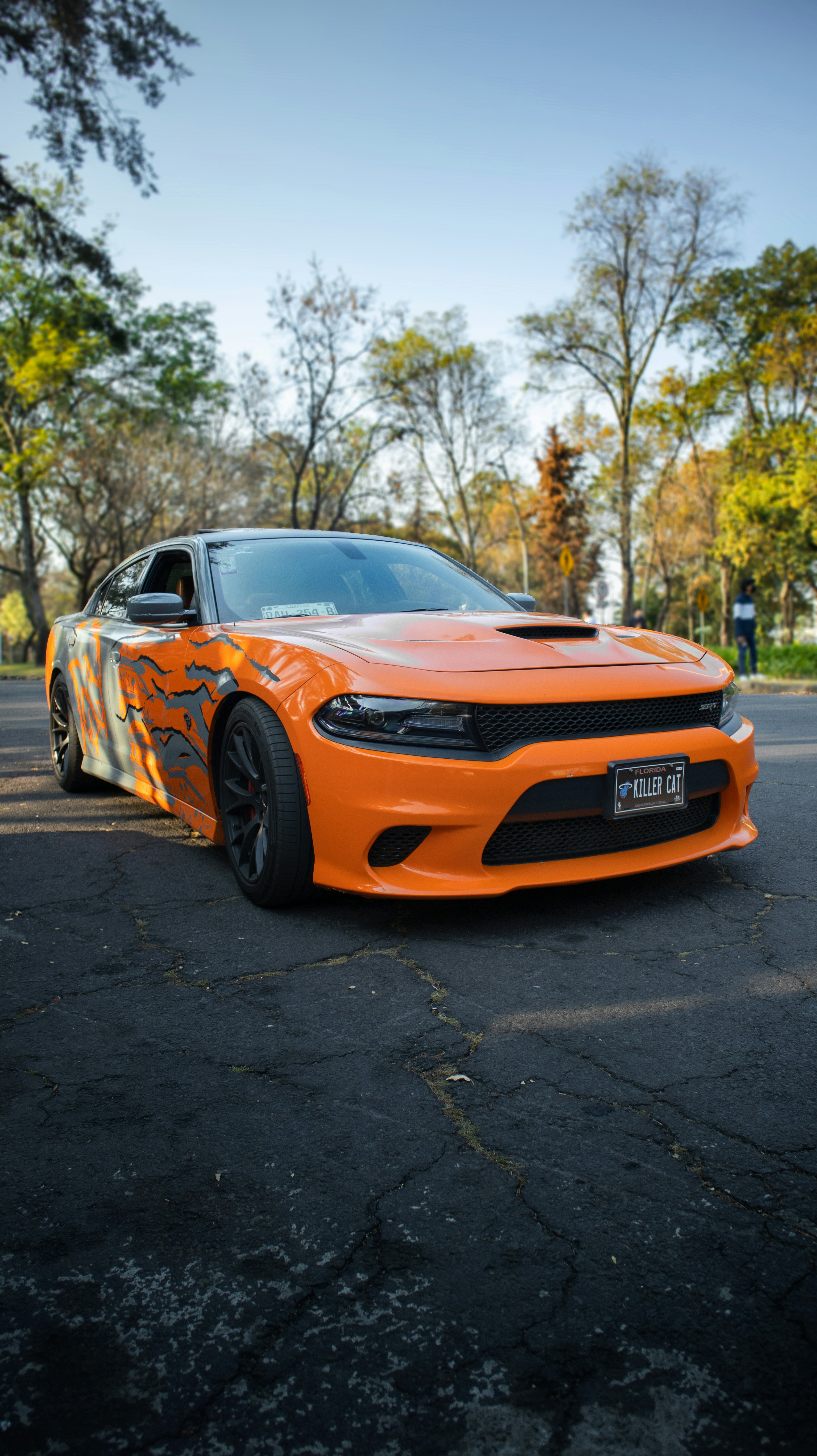 Ein orangefarbenes Dodge-Ladegerät auf einem Parkplatz geparkt