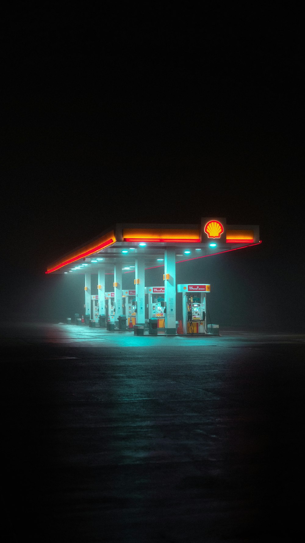 a gas station lit up at night on the water