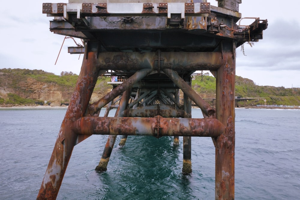 a rusted metal structure in the middle of a body of water