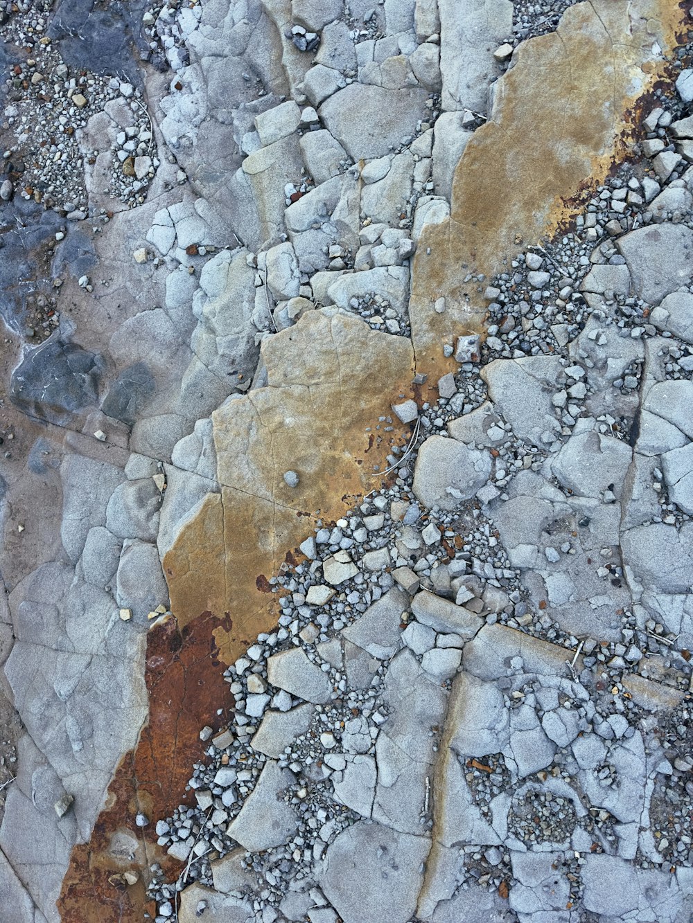 a close up of rocks and gravel with a yellow stripe
