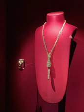 Close-up of elegant imitation gold necklaces displayed on a velvet stand