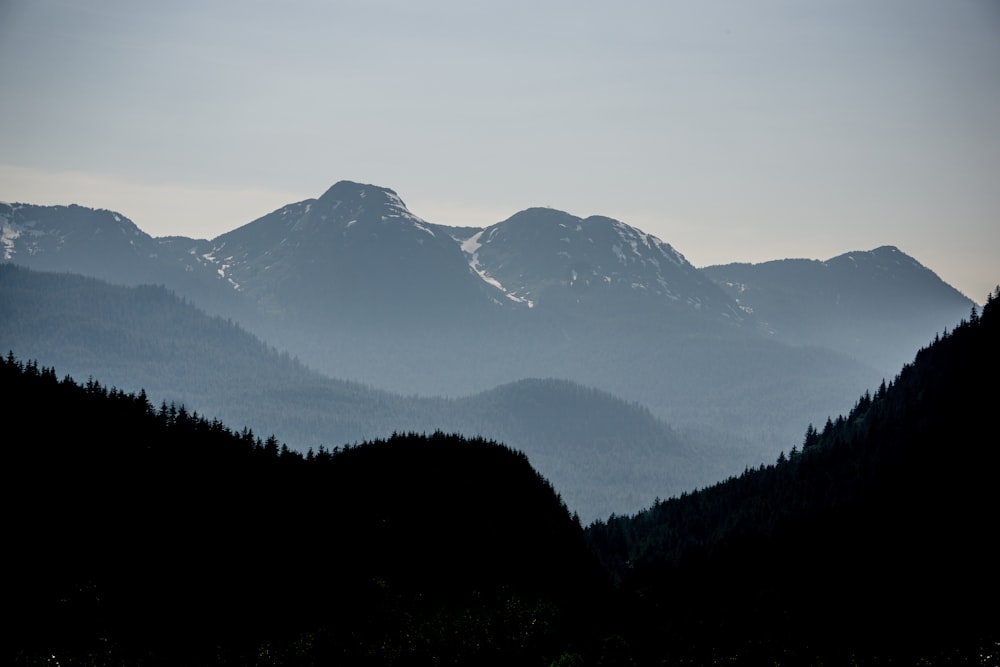 a view of a mountain range with trees in the foreground