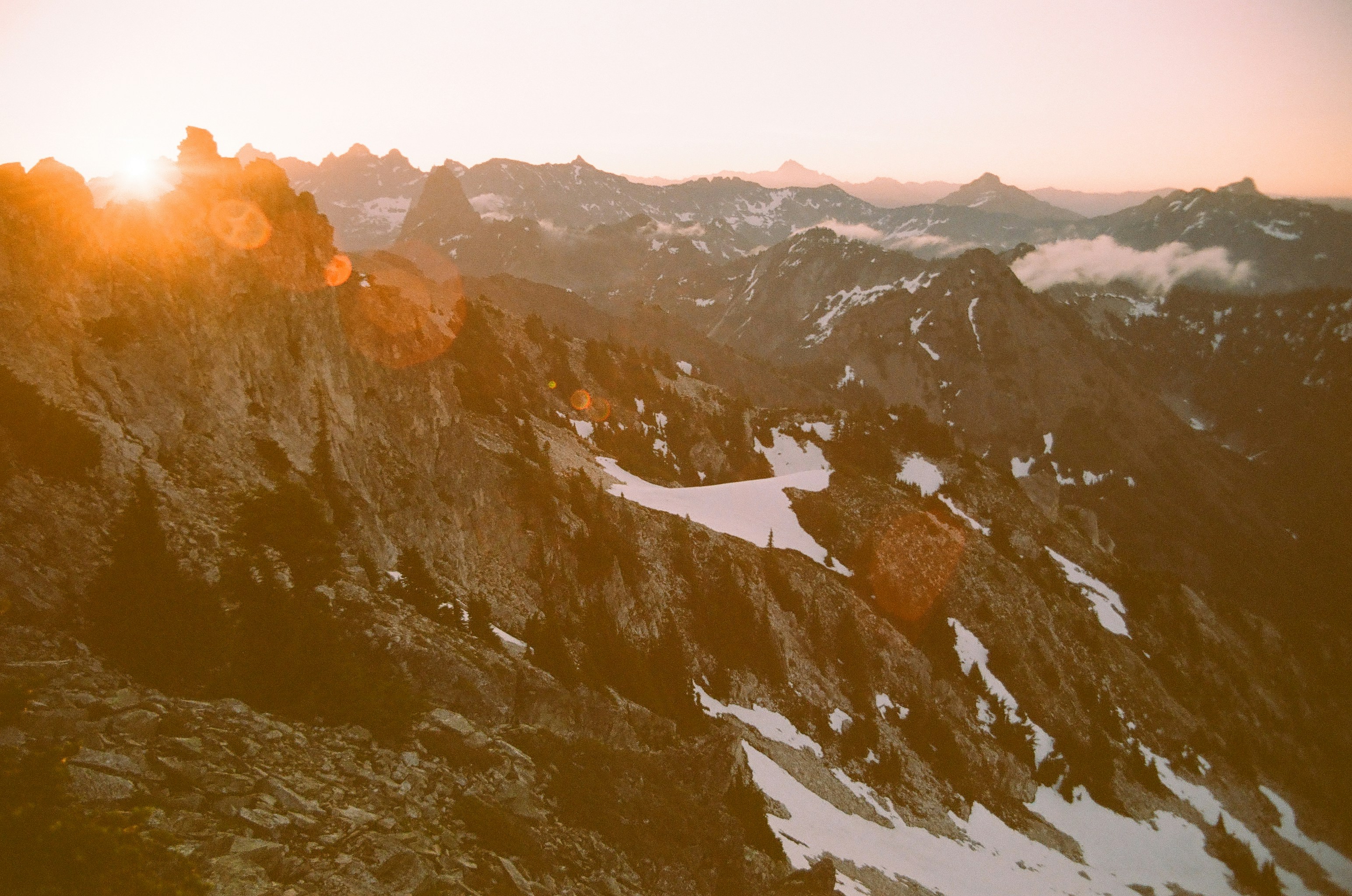 The sun shines on a snowy mountain range