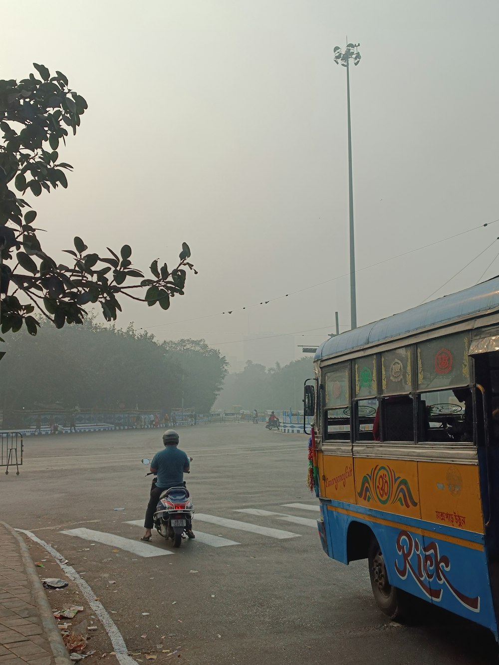 a man riding a motorcycle next to a bus