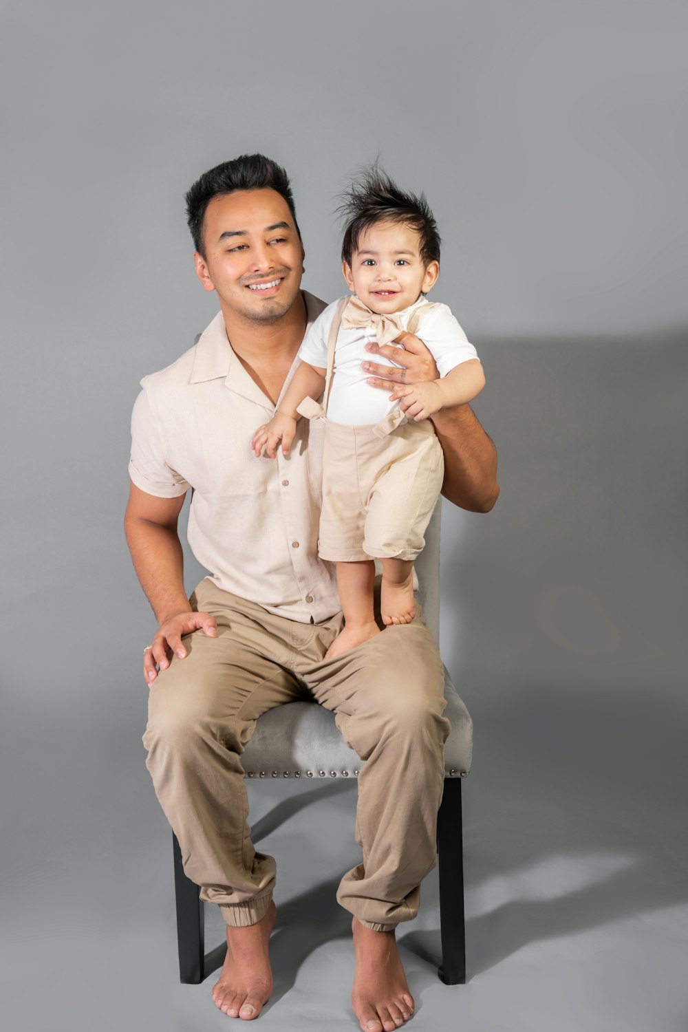 a man sitting on a chair holding a small child