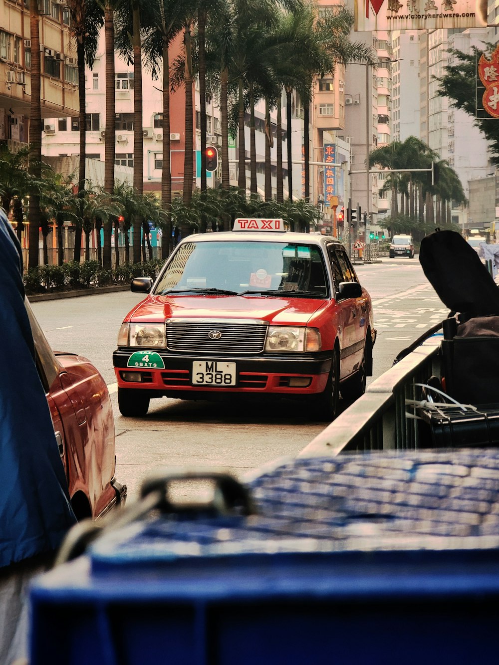 a red taxi cab driving down a street next to tall buildings